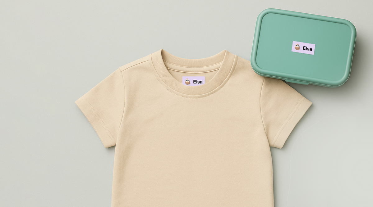 T-shirt för barn märkt med själhäftande personliga namnlappar ifrån Lappu samt en lunchlåda för barn märkt med en namnlapp